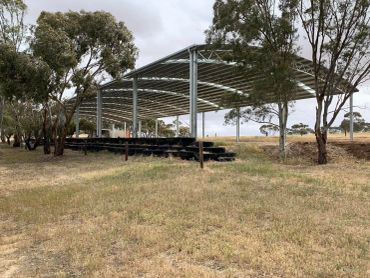 Metal pergola shade structure in rural landscape